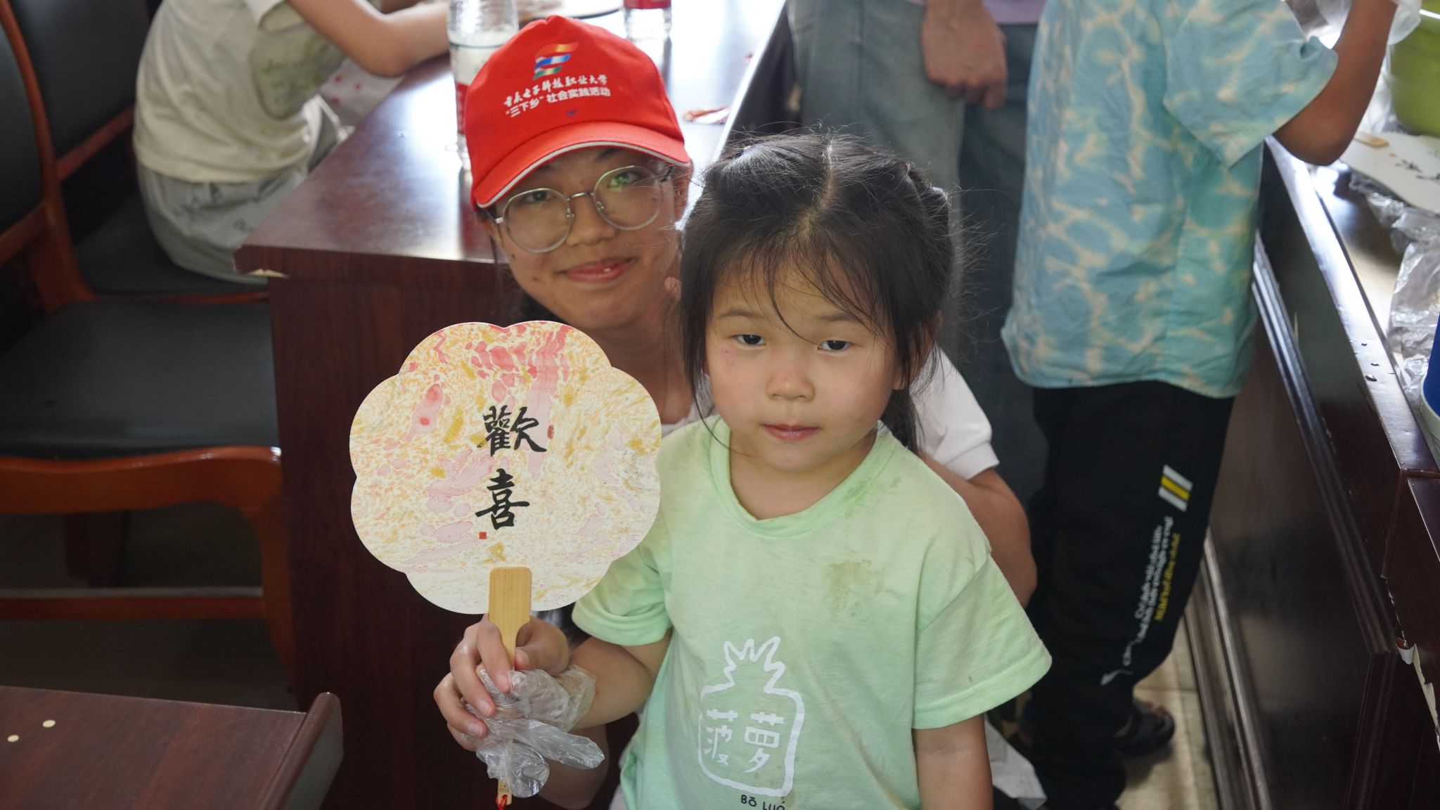 小朋友展示制作好的漆扇